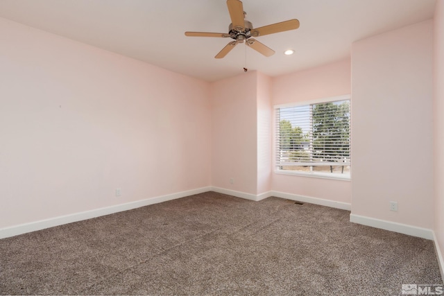 empty room featuring ceiling fan and carpet