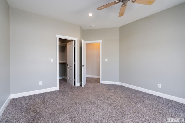 unfurnished bedroom with a walk in closet, carpet, ceiling fan, and a closet