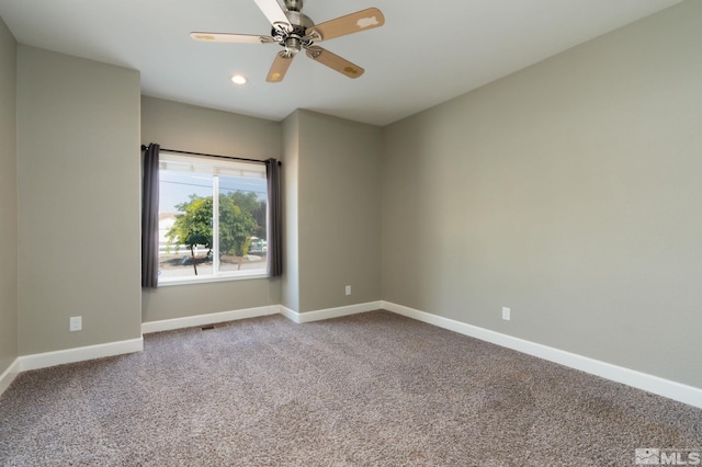 carpeted spare room featuring ceiling fan