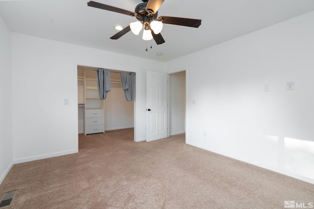 unfurnished bedroom featuring ceiling fan, light colored carpet, and a closet