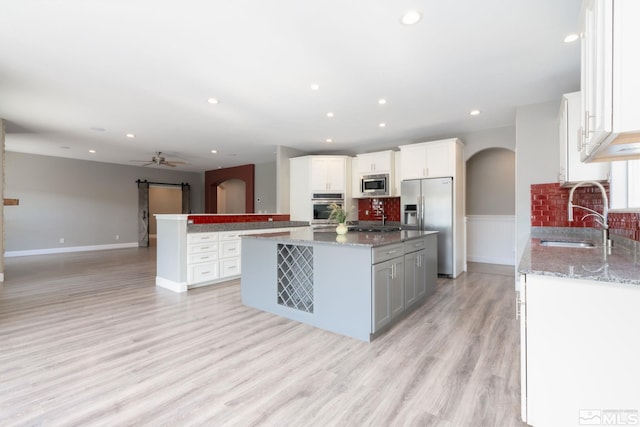 kitchen featuring white cabinetry, appliances with stainless steel finishes, a center island, and sink