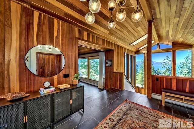 interior space with a baseboard heating unit, wooden ceiling, plenty of natural light, and vaulted ceiling