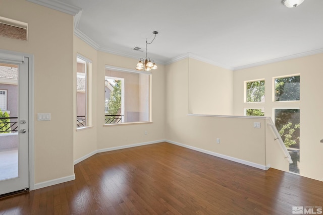 spare room with dark hardwood / wood-style floors, a chandelier, and ornamental molding