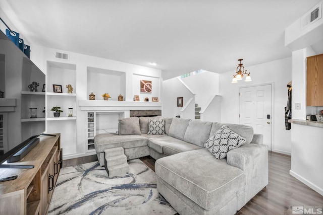 living room with an inviting chandelier and hardwood / wood-style flooring