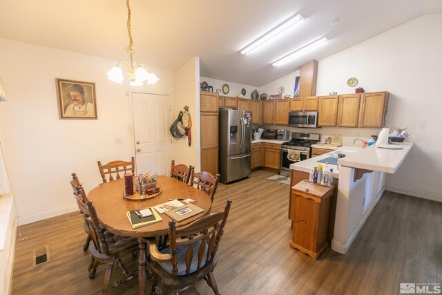 kitchen featuring dishwasher, hardwood / wood-style floors, vaulted ceiling, tile countertops, and sink