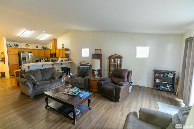 living room with lofted ceiling and hardwood / wood-style flooring