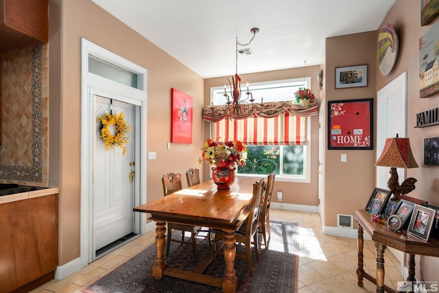 tiled dining area with an inviting chandelier