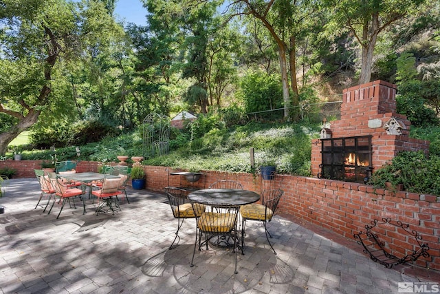 view of patio with an outdoor brick fireplace