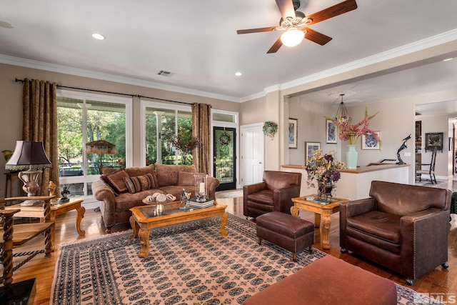 living room featuring hardwood / wood-style flooring, crown molding, and ceiling fan