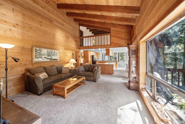 living room featuring wood ceiling, beamed ceiling, and light colored carpet