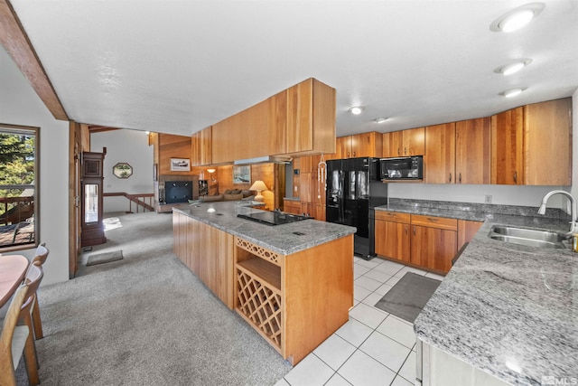 kitchen featuring sink, light carpet, light stone counters, and black appliances