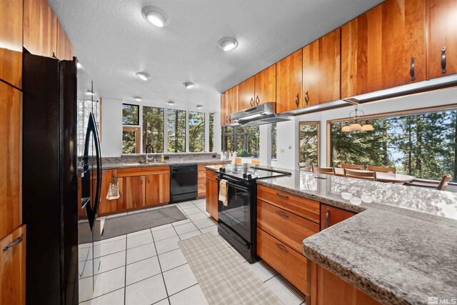 kitchen featuring sink, light stone counters, black appliances, and light tile patterned floors