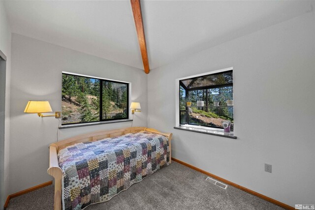 carpeted bedroom featuring multiple windows and beam ceiling