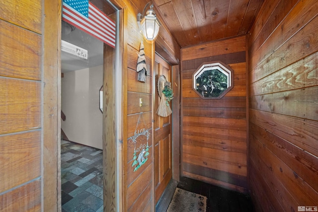 interior space featuring tile patterned flooring, wood walls, and wooden ceiling