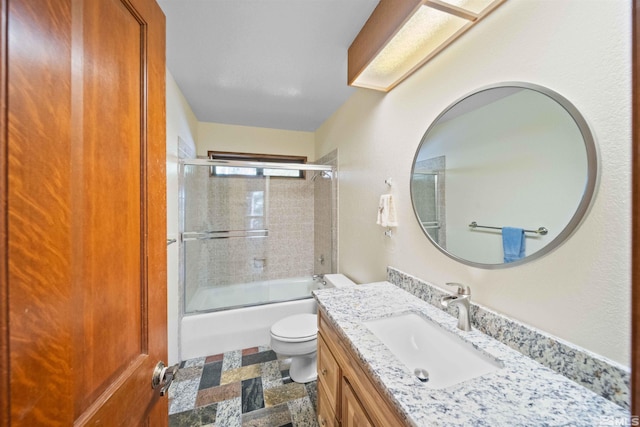 full bathroom featuring tile patterned floors, combined bath / shower with glass door, vanity, and toilet