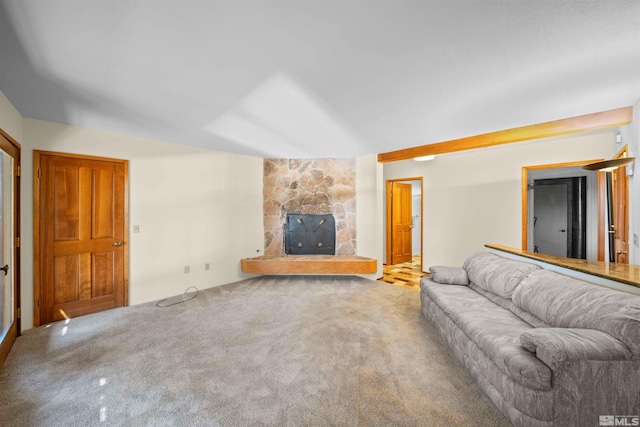 unfurnished living room with a stone fireplace and carpet flooring