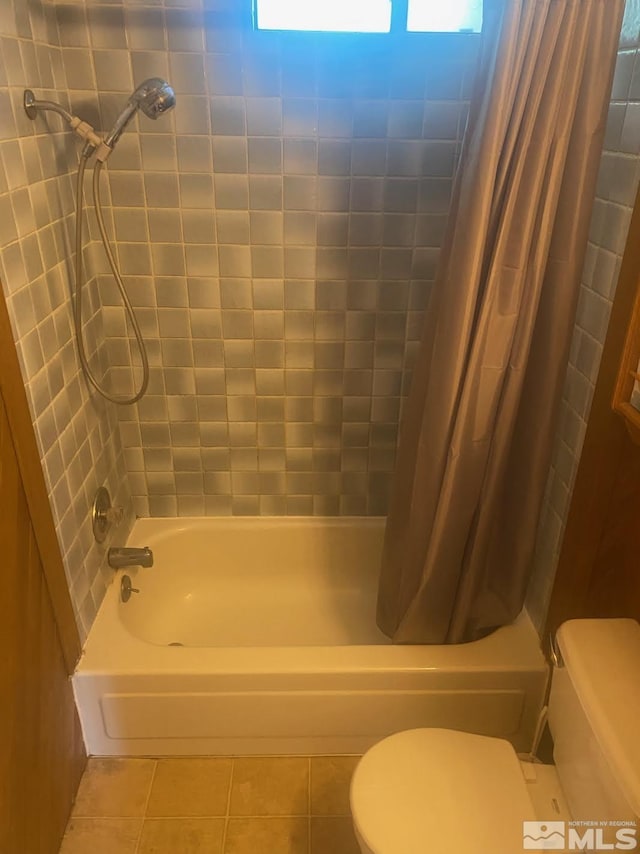 bathroom with toilet, shower / tub combo, and tile patterned flooring