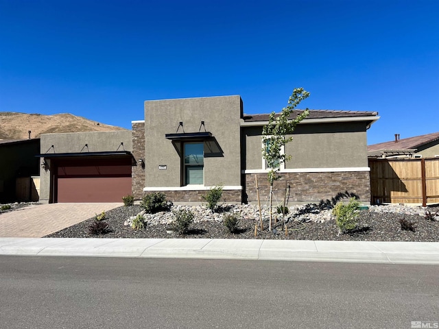 pueblo-style house featuring a garage and a mountain view