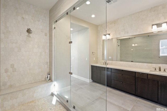 bathroom with tiled shower, tile patterned floors, and vanity