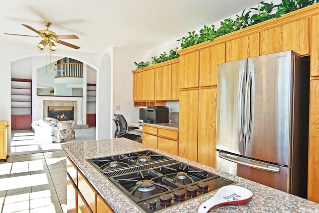 kitchen with ceiling fan, light tile patterned flooring, gas stovetop, and stainless steel fridge