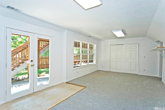 doorway to outside featuring a wealth of natural light, light carpet, and french doors