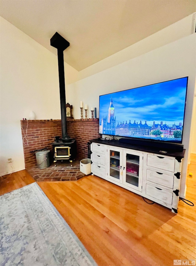 living room with a wood stove and light hardwood / wood-style flooring