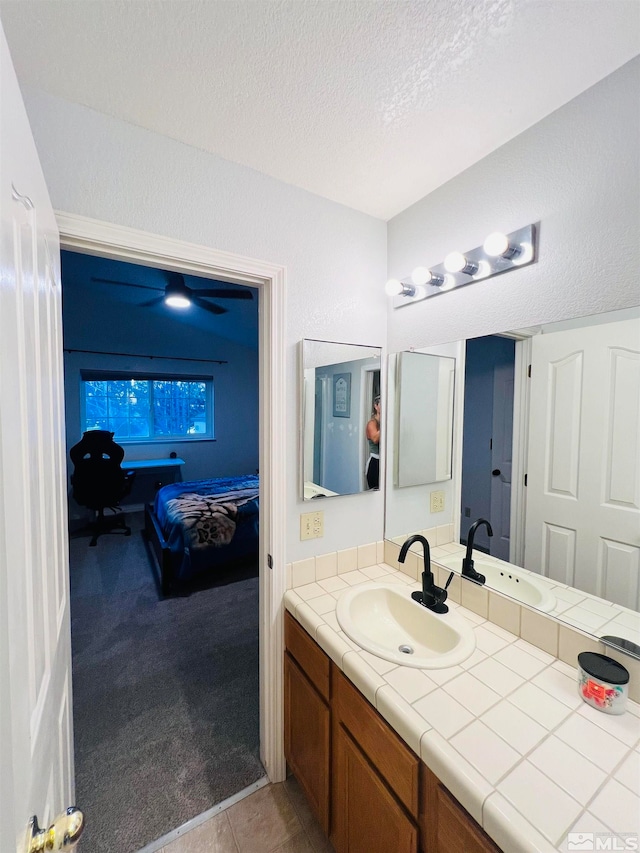 bathroom with a textured ceiling, vanity, and tile patterned flooring