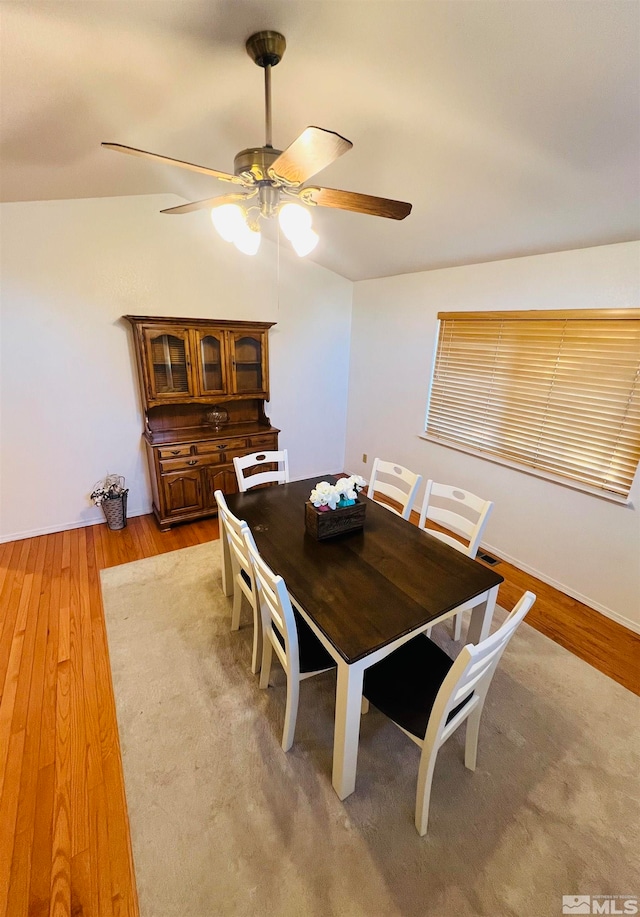 dining room with ceiling fan, lofted ceiling, and hardwood / wood-style floors