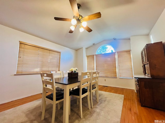 dining area with ceiling fan, light hardwood / wood-style flooring, and lofted ceiling