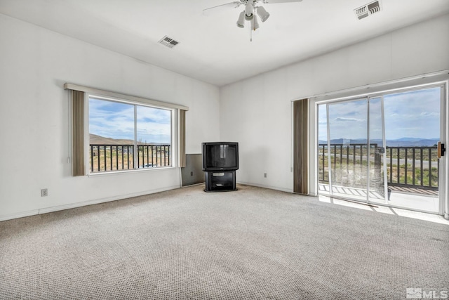 unfurnished living room featuring ceiling fan and light colored carpet