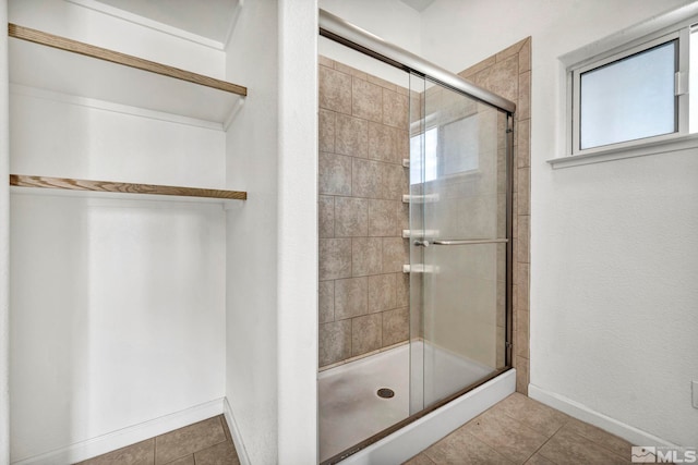 bathroom featuring a shower with door and tile patterned flooring