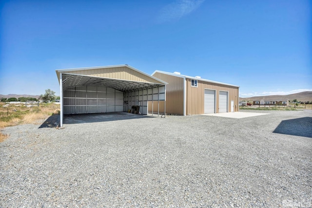 exterior space with a carport, a garage, and an outdoor structure