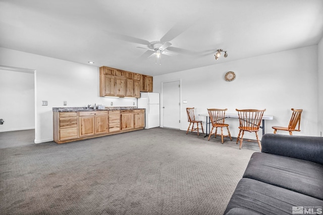 living room featuring ceiling fan, sink, and light colored carpet