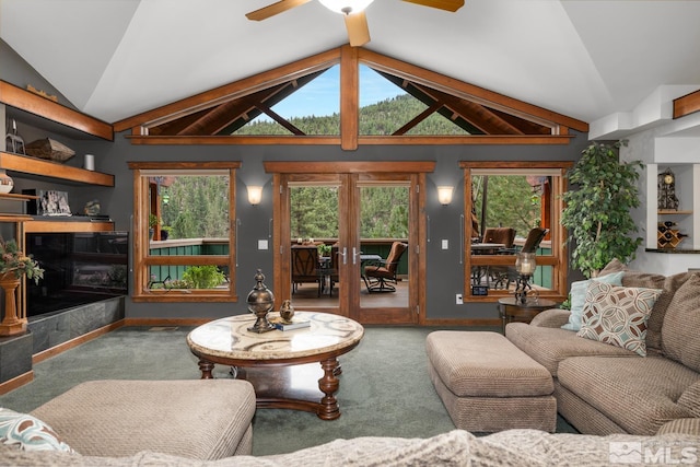 carpeted living room with beamed ceiling, a premium fireplace, plenty of natural light, and ceiling fan