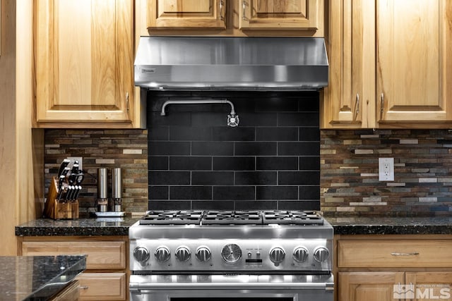 kitchen featuring backsplash, wall chimney exhaust hood, and high end stainless steel range oven