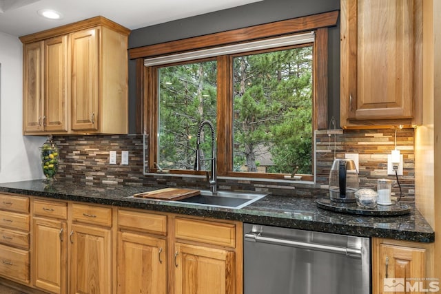 kitchen featuring tasteful backsplash, sink, dark stone countertops, and stainless steel dishwasher