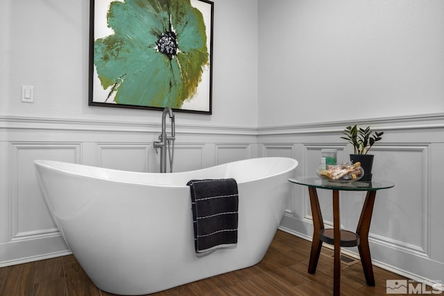 bathroom with a bathtub and hardwood / wood-style flooring