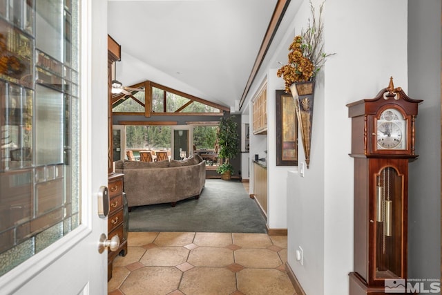 foyer entrance featuring ceiling fan, lofted ceiling, and tile patterned flooring