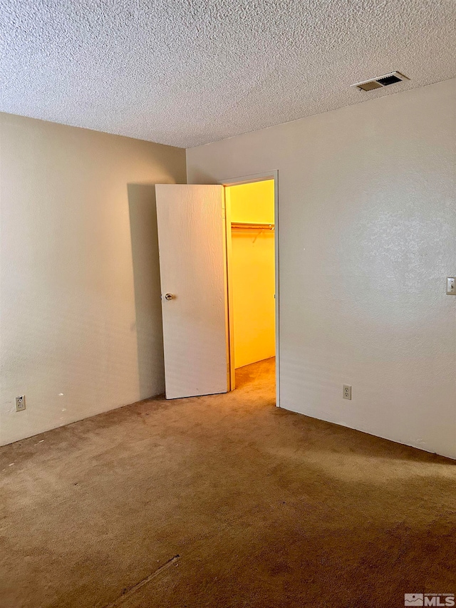 carpeted spare room featuring a textured ceiling