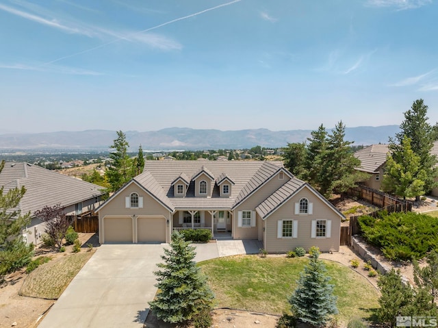 cape cod home featuring a mountain view, a front yard, and a garage