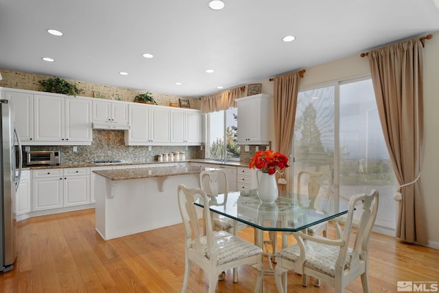 kitchen featuring a center island, white cabinetry, and a wealth of natural light