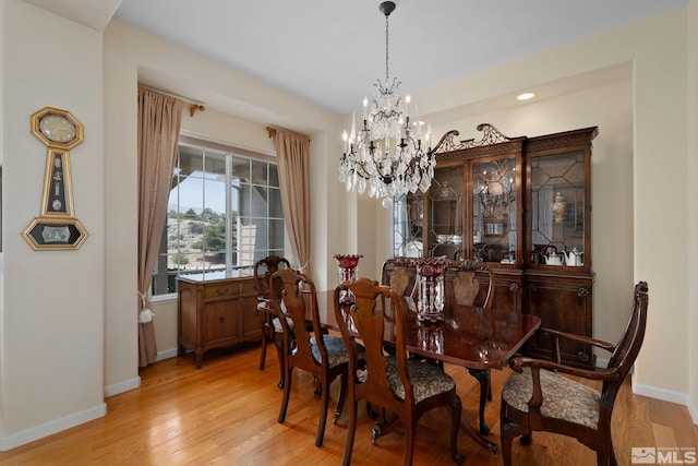 dining space featuring light hardwood / wood-style floors and a chandelier