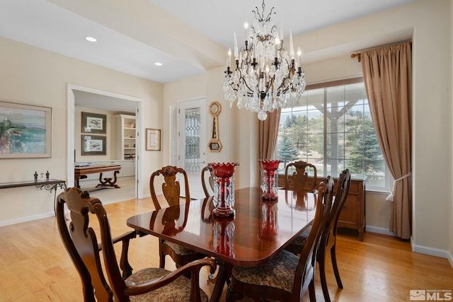 dining space featuring light hardwood / wood-style floors and a notable chandelier