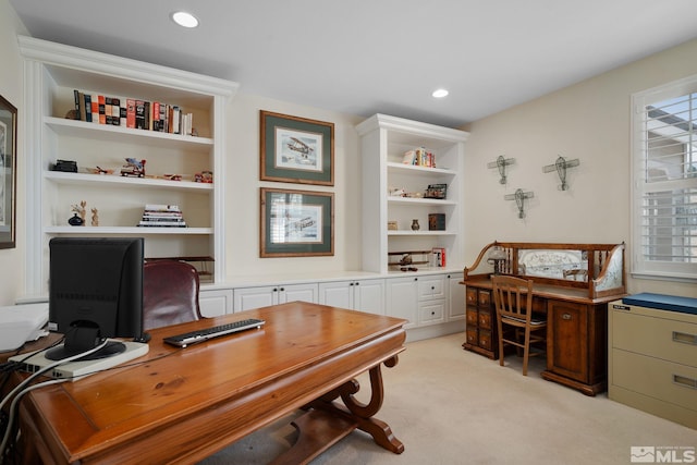 office area with built in features, built in desk, and light carpet