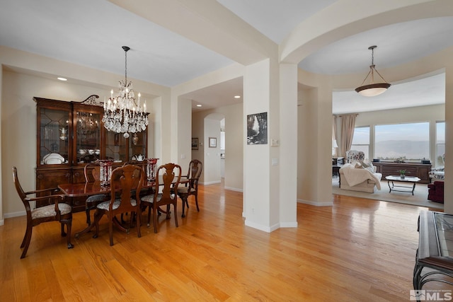 dining area with an inviting chandelier and light hardwood / wood-style floors