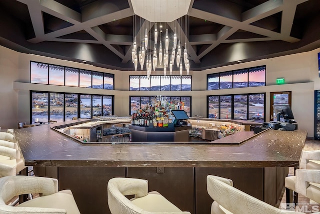 bar with coffered ceiling, a towering ceiling, and beam ceiling