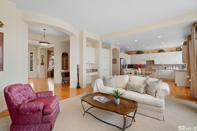 living room with sink and light hardwood / wood-style floors