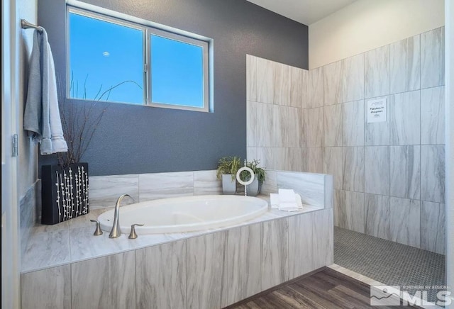 bathroom featuring a garden tub and wood finished floors