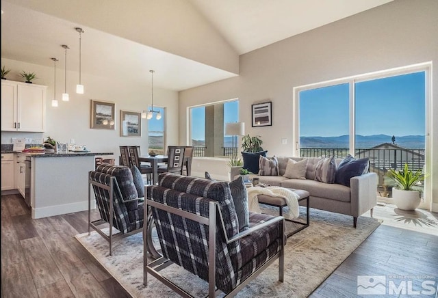 living room with high vaulted ceiling, dark wood-style flooring, and a mountain view