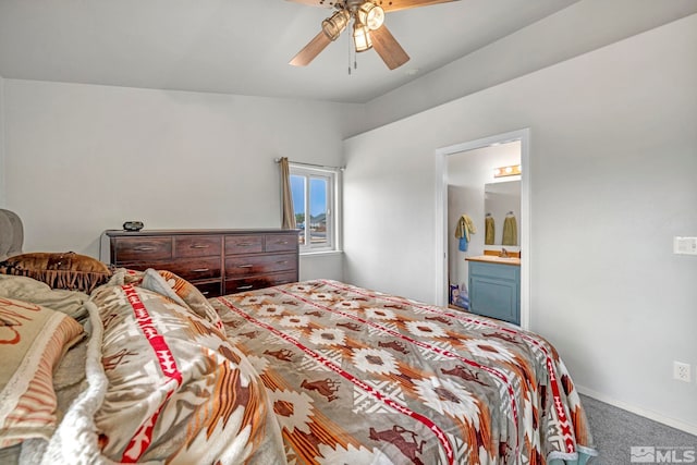 carpeted bedroom featuring ceiling fan, lofted ceiling, a sink, baseboards, and ensuite bath